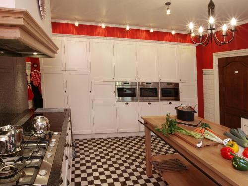 a kitchen with white cabinets and a counter with vegetables at Group Villa with Pool & Sauna in Wanze