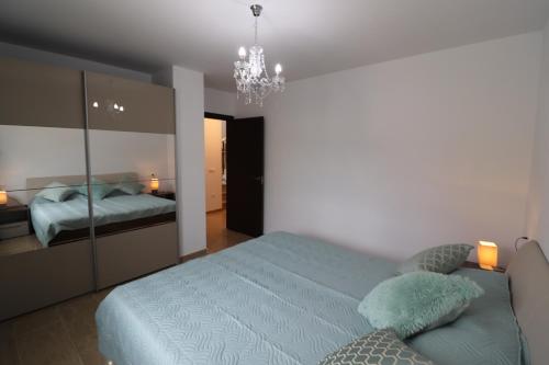 a bedroom with a bed and a chandelier at Villa Llevant in Miami Platja