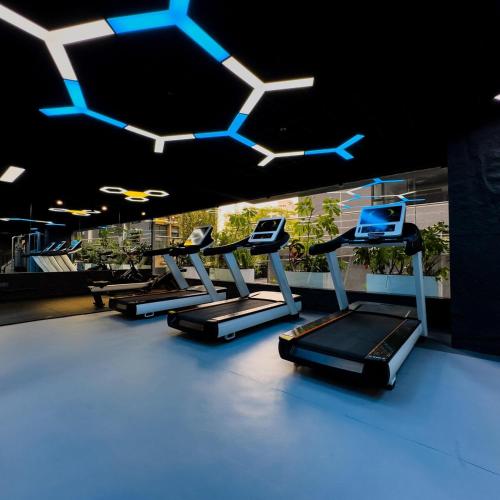 a row of cardio machines in a gym with blue lights at Lavish 2 bedroom apartment in Lavington in Nairobi
