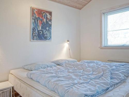 a bed in a bedroom with a painting on the wall at Idyllic Cottage in Allinge - By Traum Ferienwohnungen in Allinge