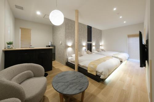 a bedroom with a large bed and a chair at Hotel QOL 瓦町 in Takamatsu