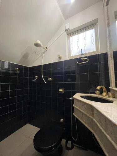 a bathroom with a toilet and a sink at Pitbox in Formiga