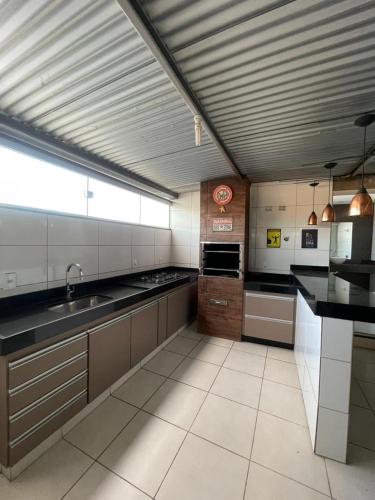 a large kitchen with a sink and a stove at Pitbox in Formiga