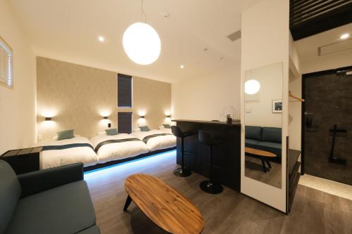 a hotel room with four beds and a desk at Hotel QOL 瓦町 in Takamatsu
