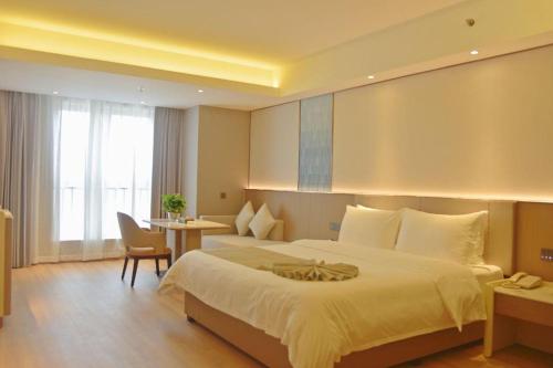 a hotel room with a large bed and a desk at Chengdu Antai Century Hotel in Chengdu