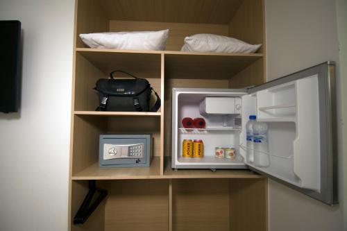 a cupboard with a small refrigerator and a bag at Hotel Granada Plaza in Manizales
