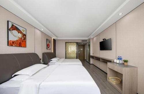 a hotel room with four beds and a flat screen tv at GreenTree Alliance Ningbo Cixi Guanghaiwei Industrial Park East Area Hotel in Ningbo