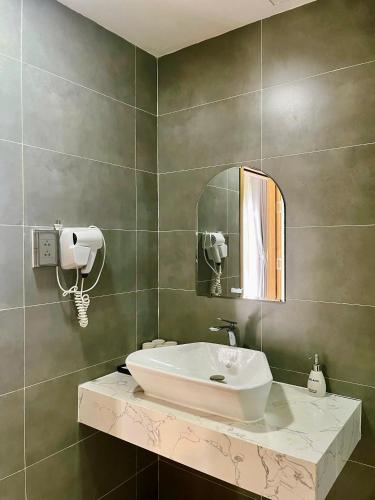 a bathroom with a sink and a mirror at Triland Hotel in Phú Quốc