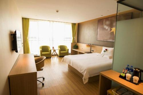 a hotel room with a bed and a desk at IU Hotel Zhangye High-Speed Railway Station in Zhangye