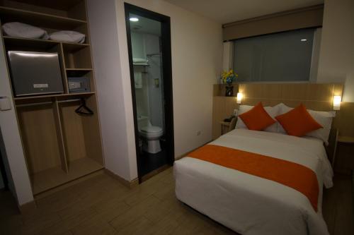a hotel room with a bed and a bathroom at Hotel Granada Plaza in Manizales