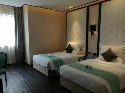 a hotel room with two beds and a window at Xana Hotelle·Tianshui Shangyi Plaza in Tianshui