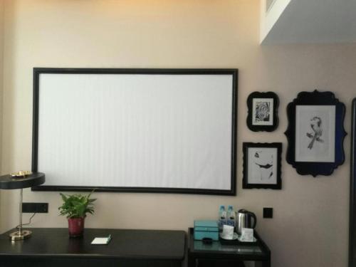 a large projection screen on a wall in a room at Xana Hotelle·Tianshui Shangyi Plaza in Tianshui