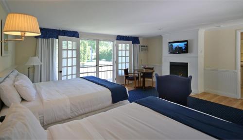 a hotel room with two beds and a fireplace at Colonial Inn Harbor Springs in Harbor Springs
