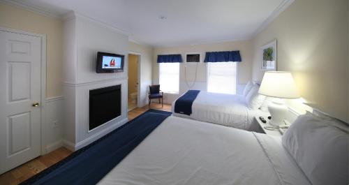 a hotel room with two beds and a fireplace at Colonial Inn Harbor Springs in Harbor Springs