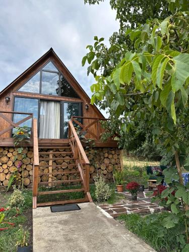 a log cabin with a staircase and a window at Tasia's Cottage in Tsalka