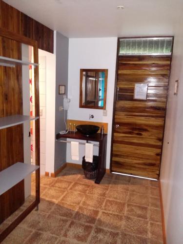 baño con lavabo y puerta de madera en Celeste Mountain Lodge, en Bijagua