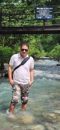 a man standing in the water in a river at dreamy orchard -myst in Nakraunda