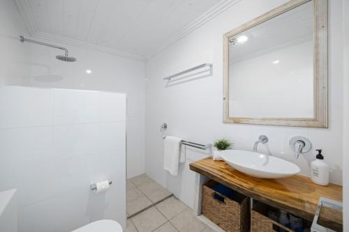 a white bathroom with a sink and a mirror at Riverside Retreat North Haven in North Haven