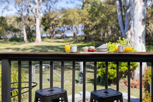 a table with food and drinks on a balcony at Riverside Retreat North Haven in North Haven