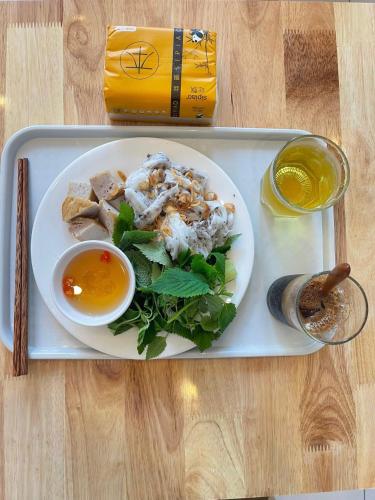 a tray with a plate of food on a table at Lanxy Hotel Nha Trang in Nha Trang