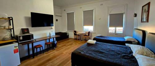 ein Wohnzimmer mit einem Bett und einer Couch in der Unterkunft Alpine Heritage Motel in Goulburn