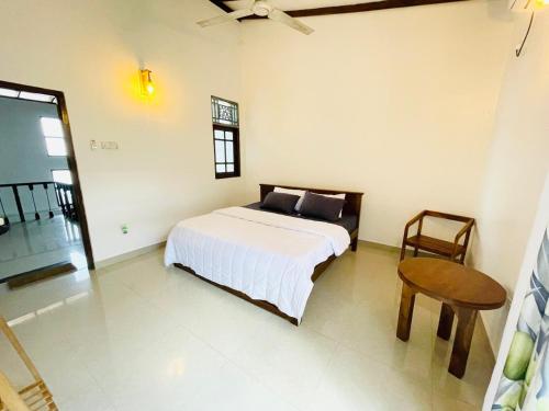 a bedroom with a bed and a table and a chair at House with Private Pool Perfect for Family Holiday in Mount Lavinia