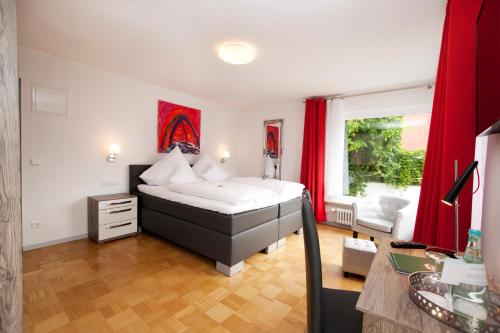 a bedroom with a king sized bed and red curtains at Hotel Vintage Am Bundesbank-Bunker in Cochem