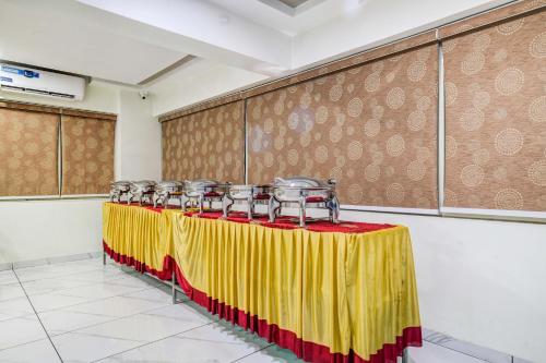 a row of tables with a yellow and red table cloth at Super Townhouse Oak PTC Indore Junction in Indore