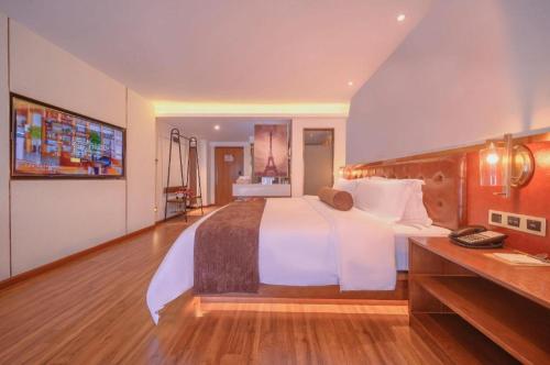 a hotel room with a large bed and a television at James Joyce Coffetel Wuhan Gutian Er Road Metro Station in Wuhan