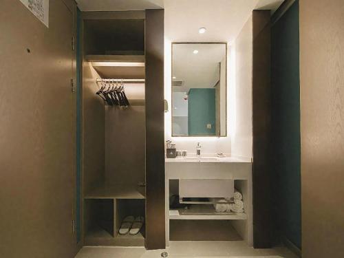 a bathroom with a sink and a mirror at Magnotel Hotel Wuhan Jiangtan Lihuangpo Road Pedestrian Street in Wuhan