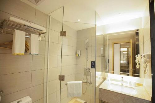 une salle de bain avec une douche en verre et un lavabo dans l'établissement City Comfort Inn Qingyuan Yingde Weiduoli Square, à Yingde