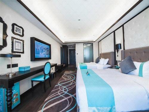 a hotel room with a large bed and a desk at Xana Hotelle Jinan Wuanfu Interchange Huafu International Square in Jinan