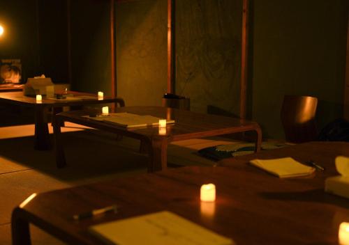 a dark room with a table and candles on it at Local Knot Backpackers in Nagano