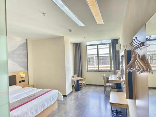 a hotel room with a bed and a table and chairs at Thank Inn Plus Hotel Guangdong Yunfu Luoding City Municipal in Yunfu