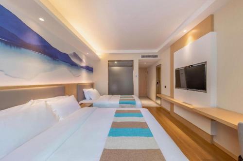 a hotel room with two beds and a flat screen tv at VX Hotel Xiamen Siming District Xiamen University Huandao Road in Xiamen