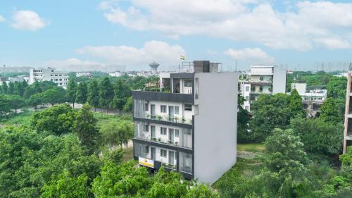 a white building in the middle of a city at Lime Tree Hotel & Stays Greater Noida Nearby India Expo Centre & Mart in Greater Noida