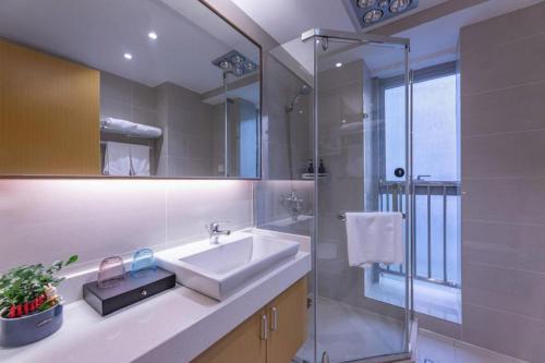 a bathroom with a sink and a shower at VX Hotel Wuxi Xinwu District Executive Center Wanda Plaza in Wuxi