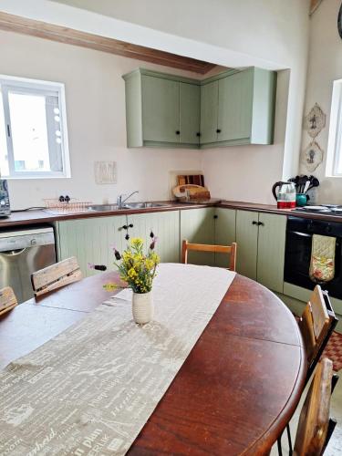 a kitchen with a table with a vase of flowers on it at Tweede Lente in St Helena Bay