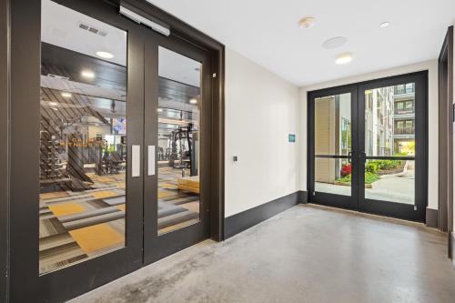 a hallway with glass doors with a gym at Stylish 1BR Retreat in Houstons Sawyer Yard Art District Minutes to Downtown in Houston