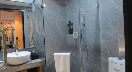a bathroom with a glass shower with a sink and a toilet at Green Tree Inn Express Fuzhou Three Lanes and Seven Alleys Nanmendou Metro Station in Fuzhou