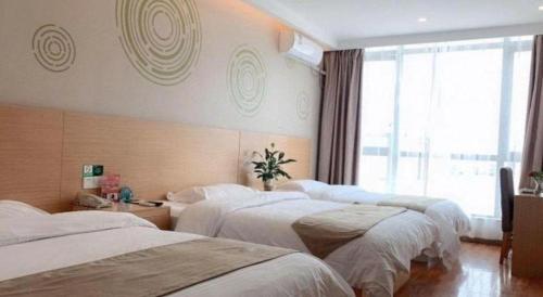 a hotel room with three beds and a window at Green Tree Inn Fengxian New City Metro Station Jiukeshu Art Center in Shanghai