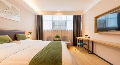 a hotel room with a bed and a desk and a tv at GreenTree Inn Express Chuzhou Langya District Government Chuhe Road in Chuzhou