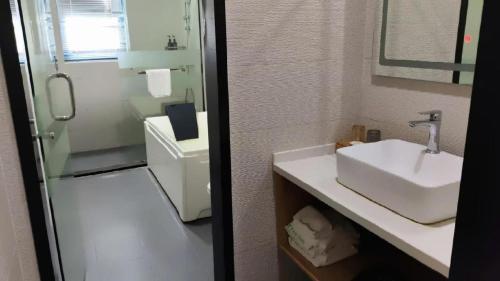a white bathroom with a sink and a shower at Green Tree Inn Changzhou Liyang Zhongguancun Innovation Park in Liyang