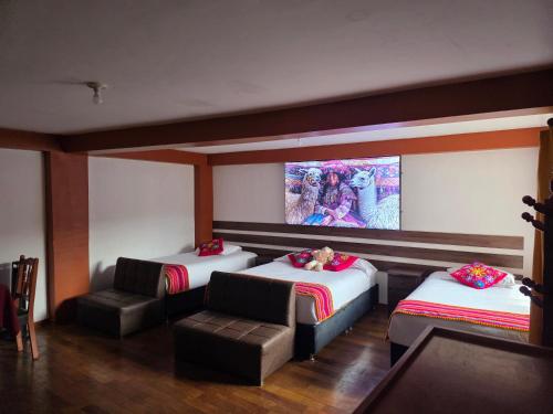a room with two beds and a tv on the wall at All Sur cusco in Cusco