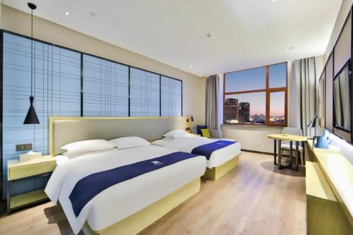 Ένα ή περισσότερα κρεβάτια σε δωμάτιο στο Echarm Hotel Hengshui 2nd High School High-speed Railway Station