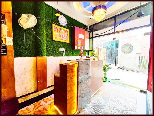 a kitchen with green walls and a counter in a room at AYODHYA PREMIUM HOTEL NIRMALA GRAND PALACE - Near Railway Station - 400 Meter Walking Distance From SHREE RAM MANDIR & 300 Meter From HANUMAN GARHI TEMPLE - #Restaurant #Wifi #Free Parking Available - Best Seller Hotel In Ayodhya in Ayodhya