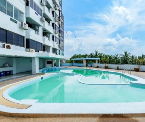 a swimming pool in front of a building at Sea View and Hill View Room for 6 Guests, Bangsaen Royal Beach by Cozy Corner in Ban Laem Thaen