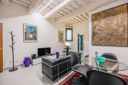 a living room with a glass table and chairs at Suite d'Art - Centro Storico di Arezzo in Arezzo