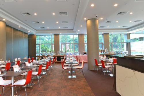 a dining room with tables and red chairs at Hotel Chancellor@Orchard in Singapore