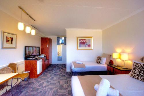 a hotel room with a bed and a couch at The Sandridge Motel in Lorne